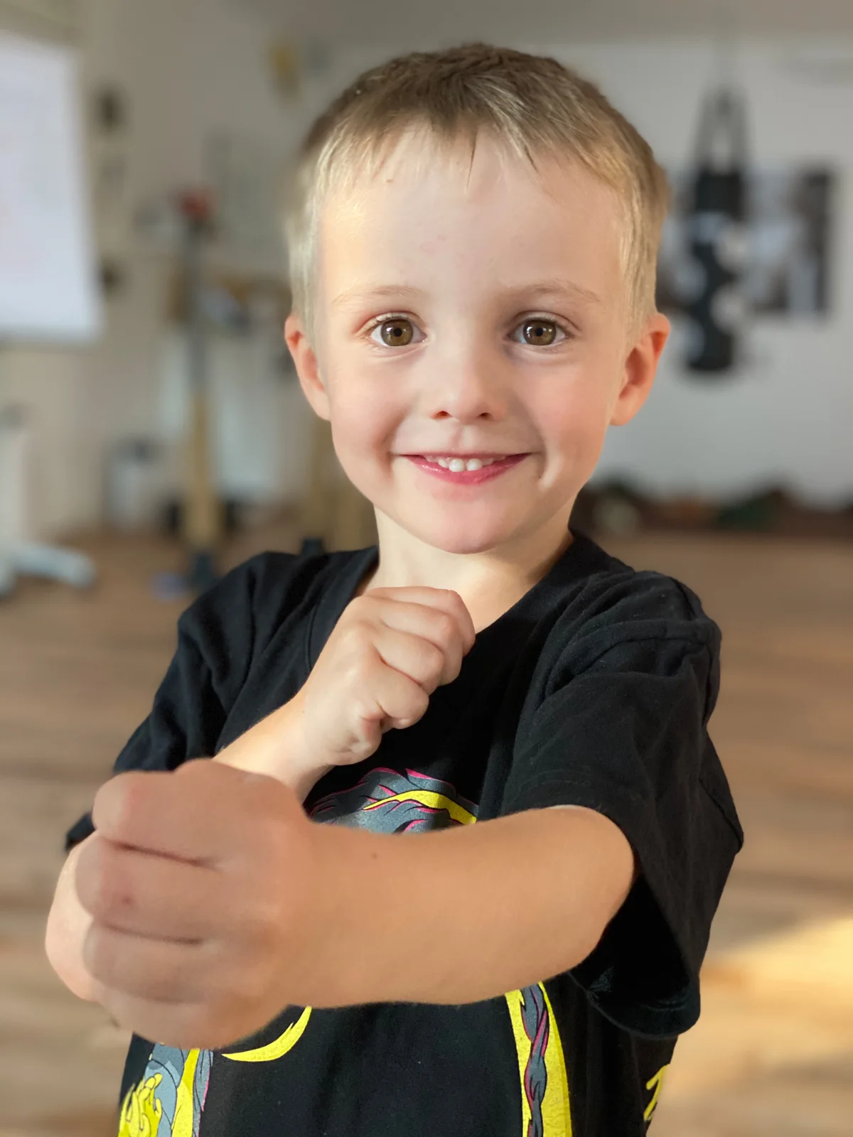 Ein Kind zeigt lächelnd eine Wing-Chun-Haltung im Kampfkunsttempel