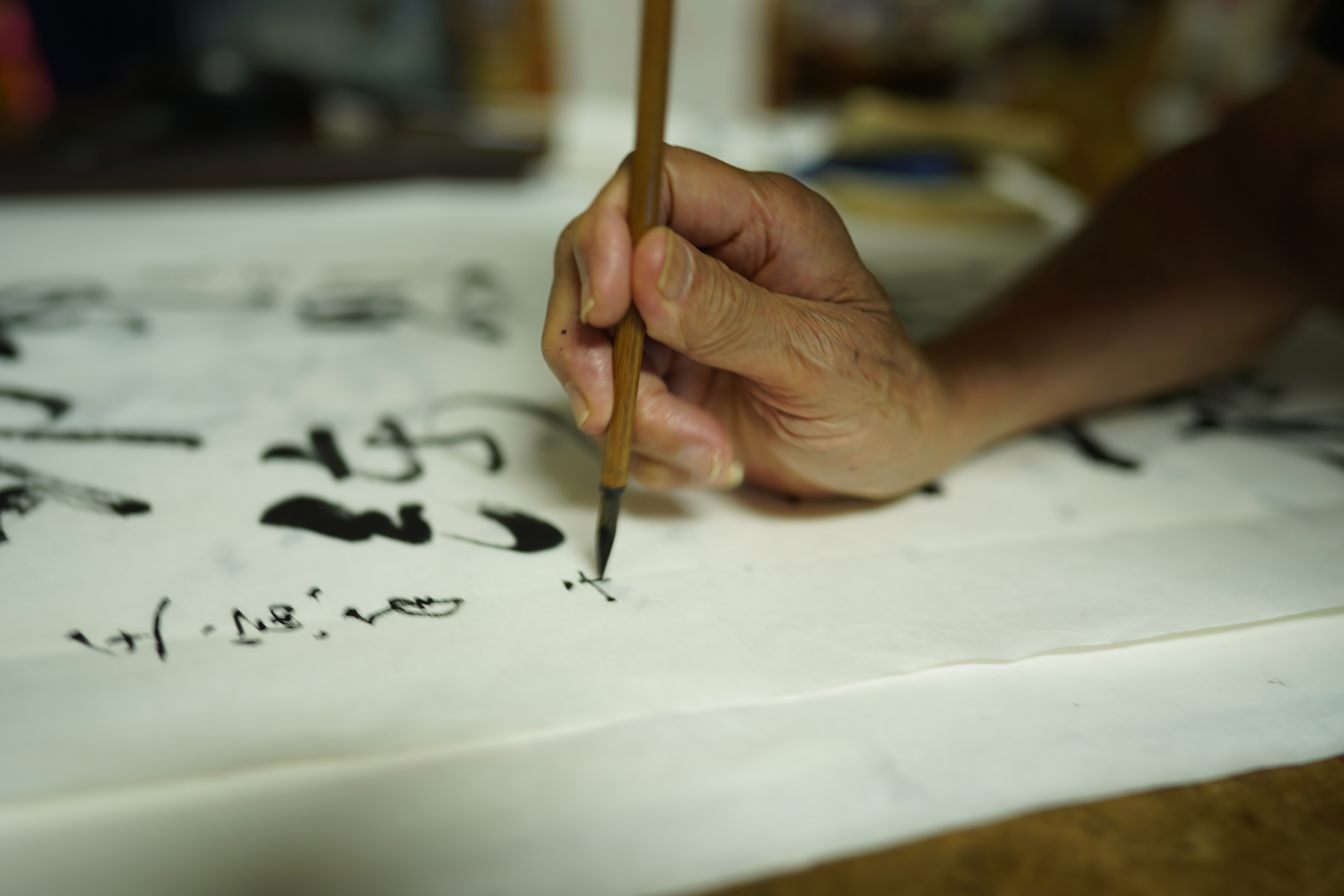 Originalaufnahme: ein Pinsel setzt eine Spur auf Kalligraphiepapier